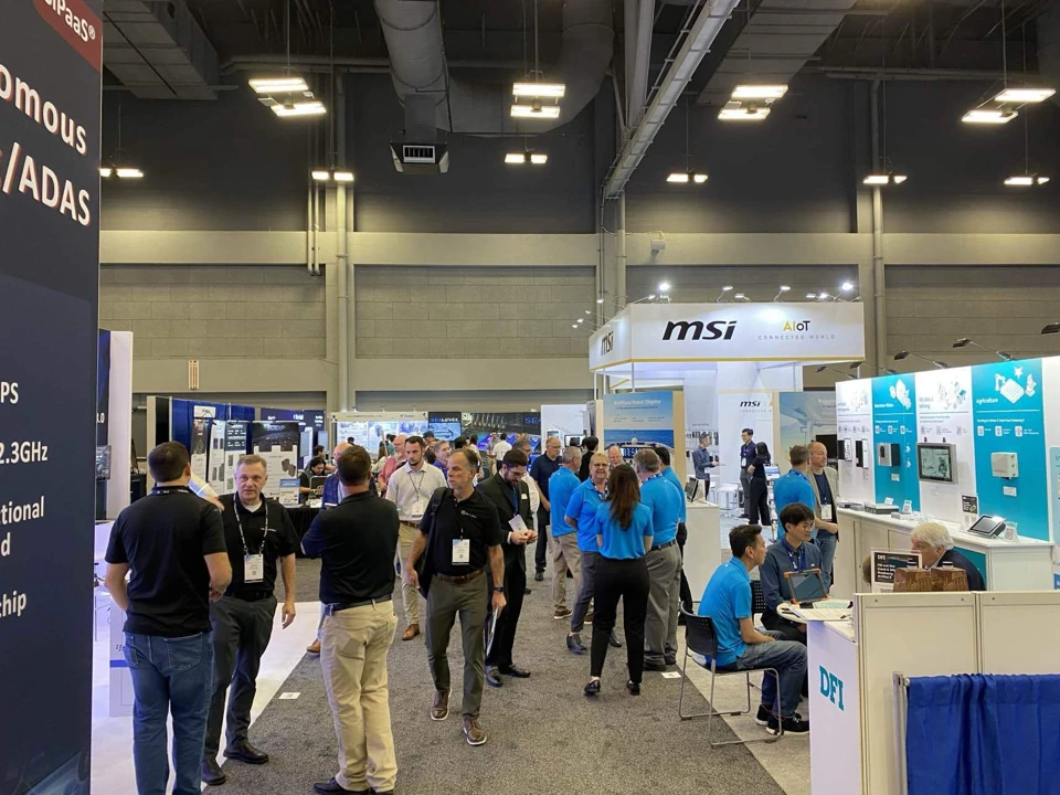 Closer view of expo booths with attendees talking and exploring displays, including companies like "msi" and "DFI."