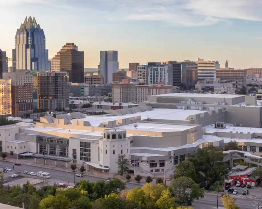 Skyline of Austin, Texas, featuring modern buildings and a large convention center in the foreground.